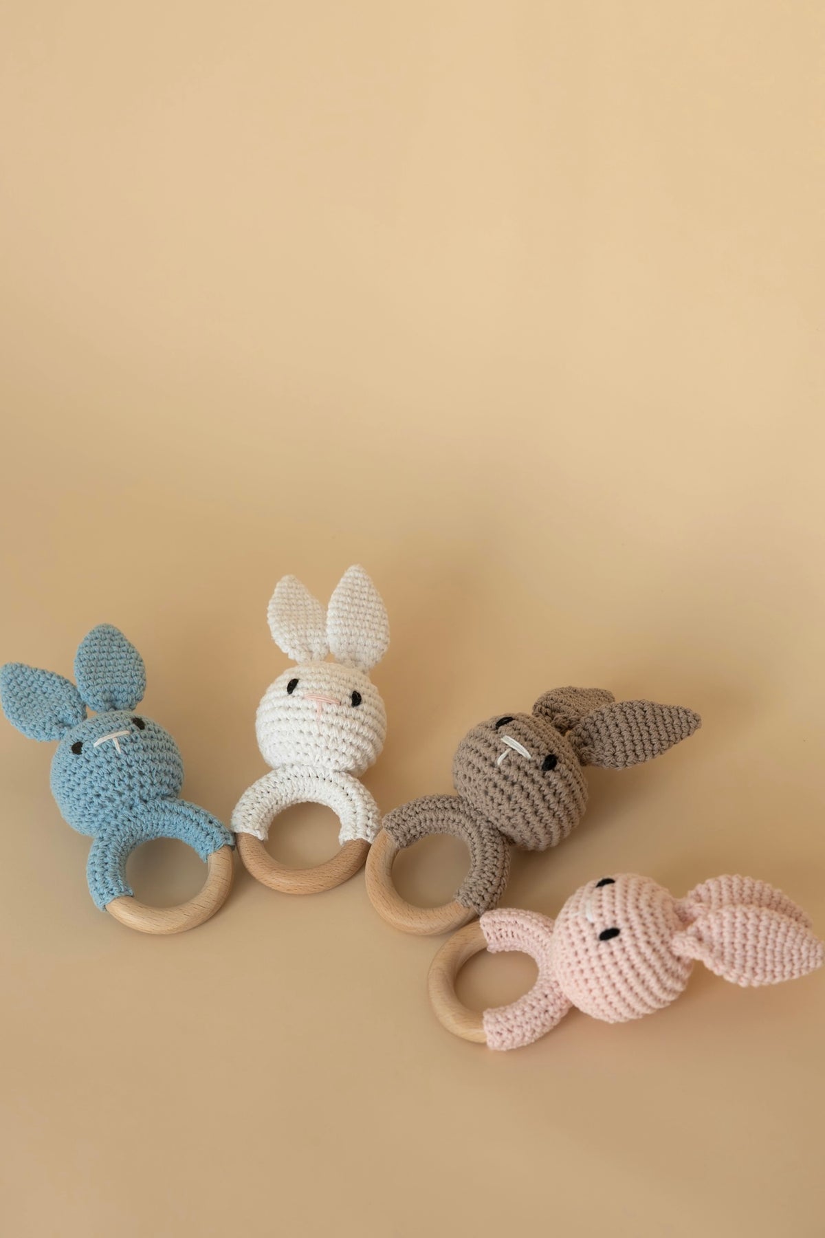 Personalised crochet bunny teethers in pink, blue, cream and beige with natural beechwood rings
