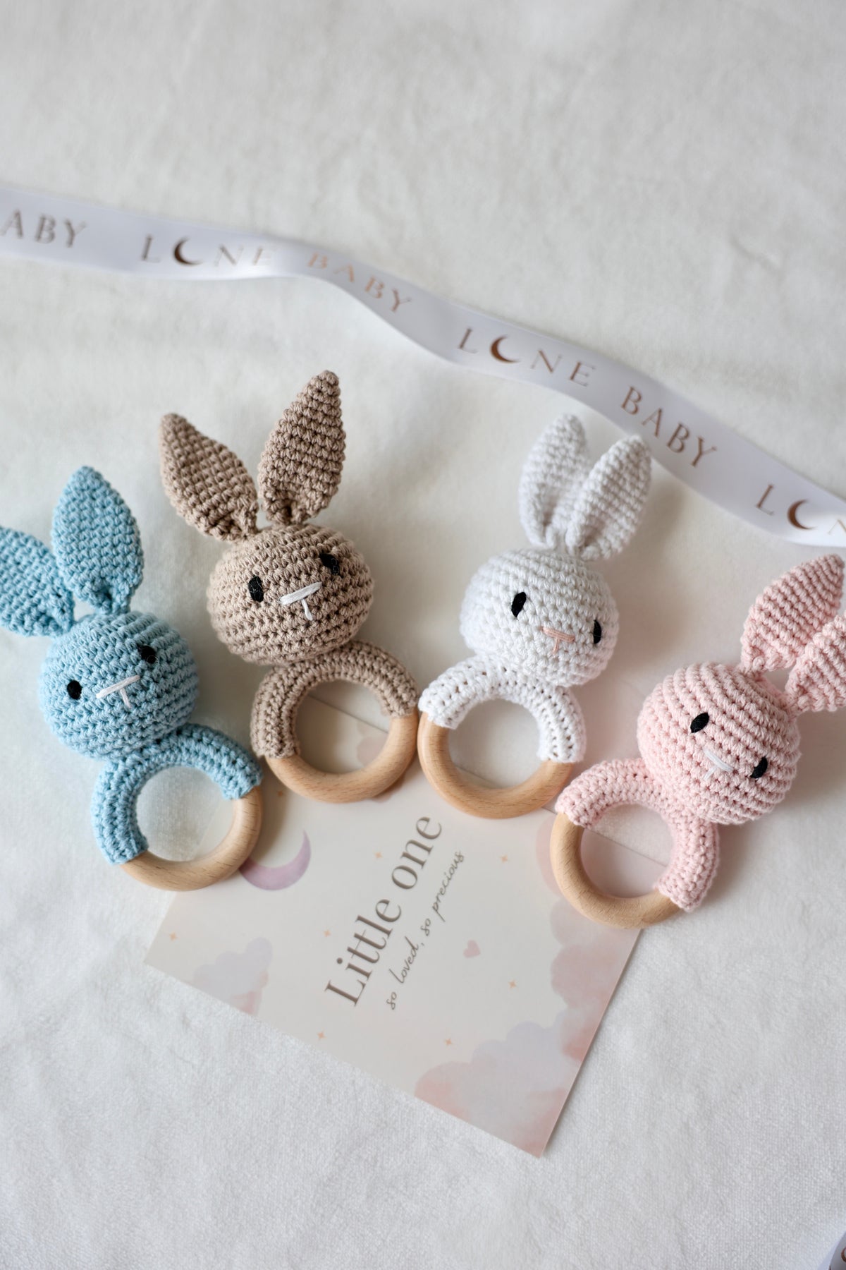 Crochet bunny teether toys with natural wooden rings in blue, beige, white and pink