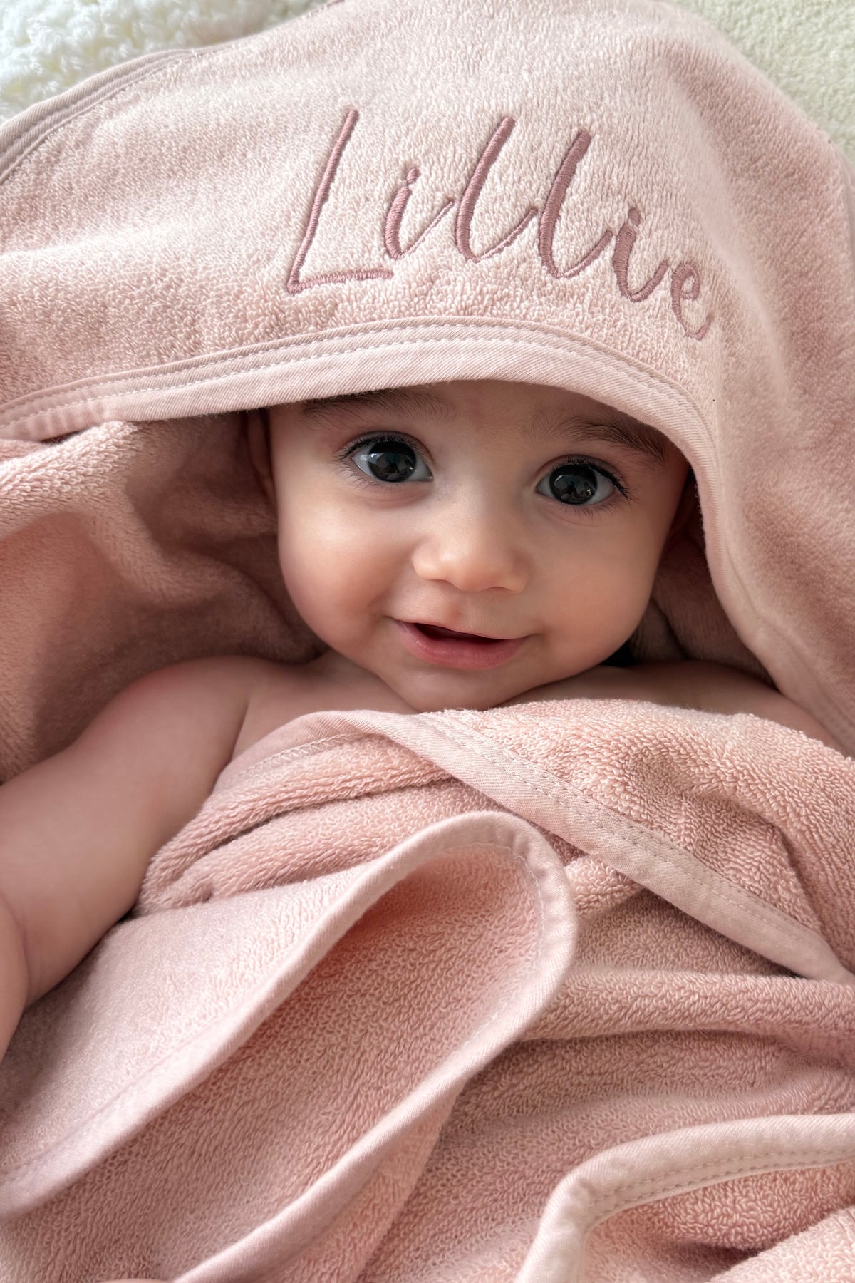 Personalised pink baby hooded towel with embroidered name and soft cotton fabric