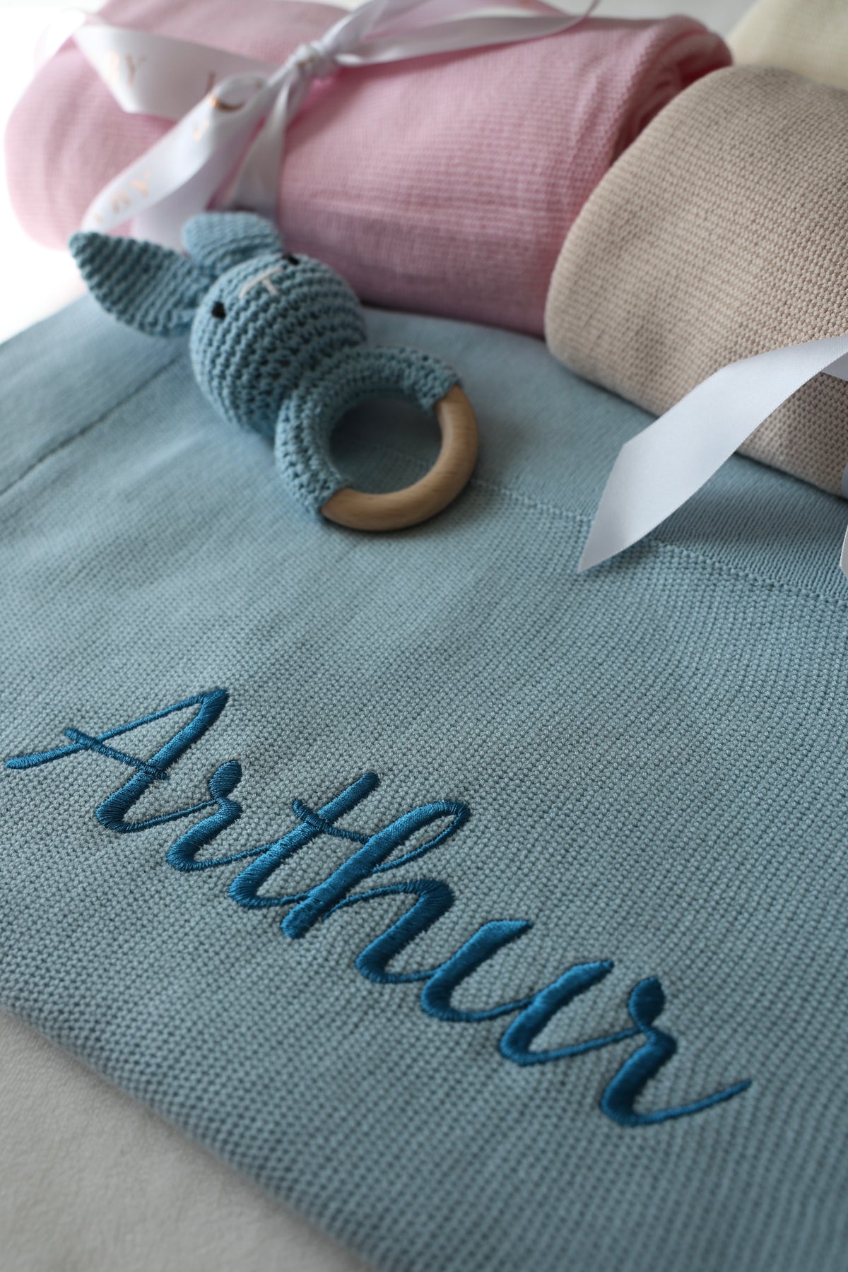 Personalised knitted cotton baby blanket in blue with embroidered name and bunny comforter