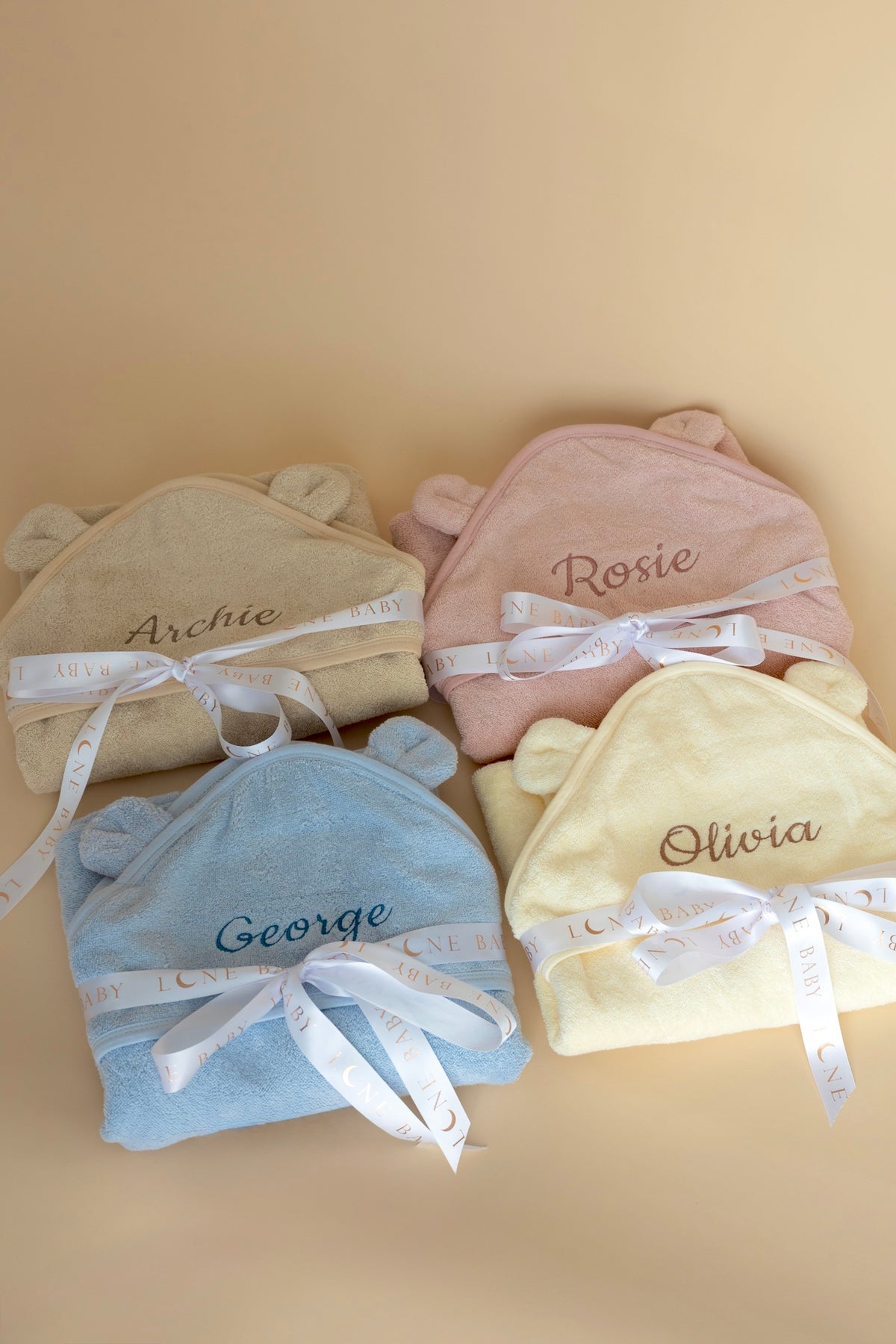 Personalised baby hooded towels in pink, blue, cream and beige with embroidered names